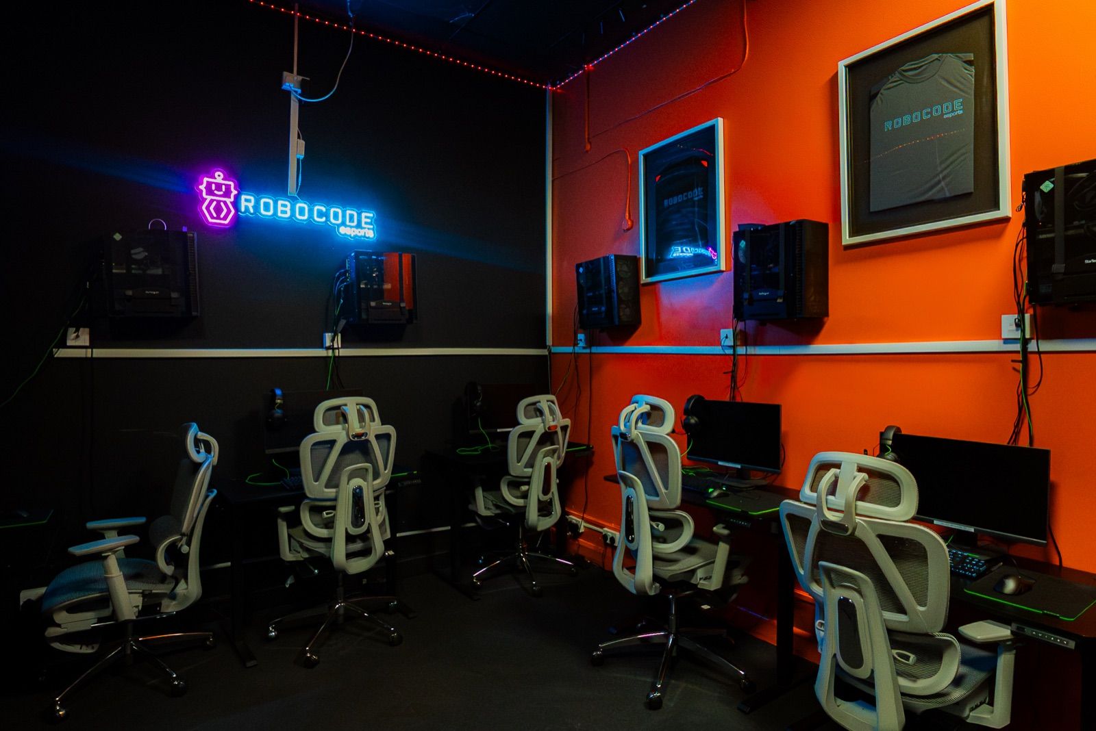 The esports room with gaming stations and a neon Robocode sign