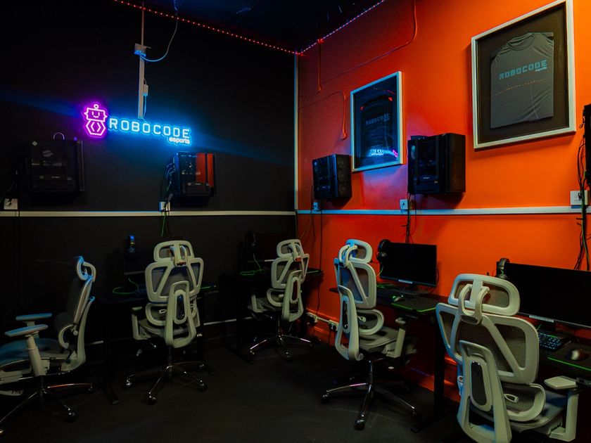 The esports room with gaming stations and a neon Robocode sign