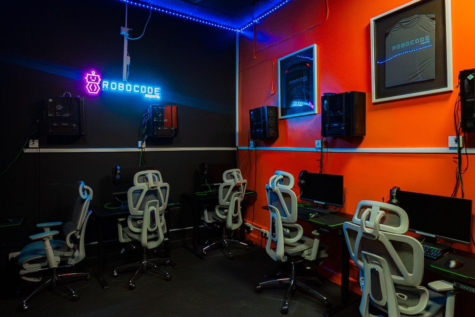 The esports room, lit in orange, with its gaming chairs