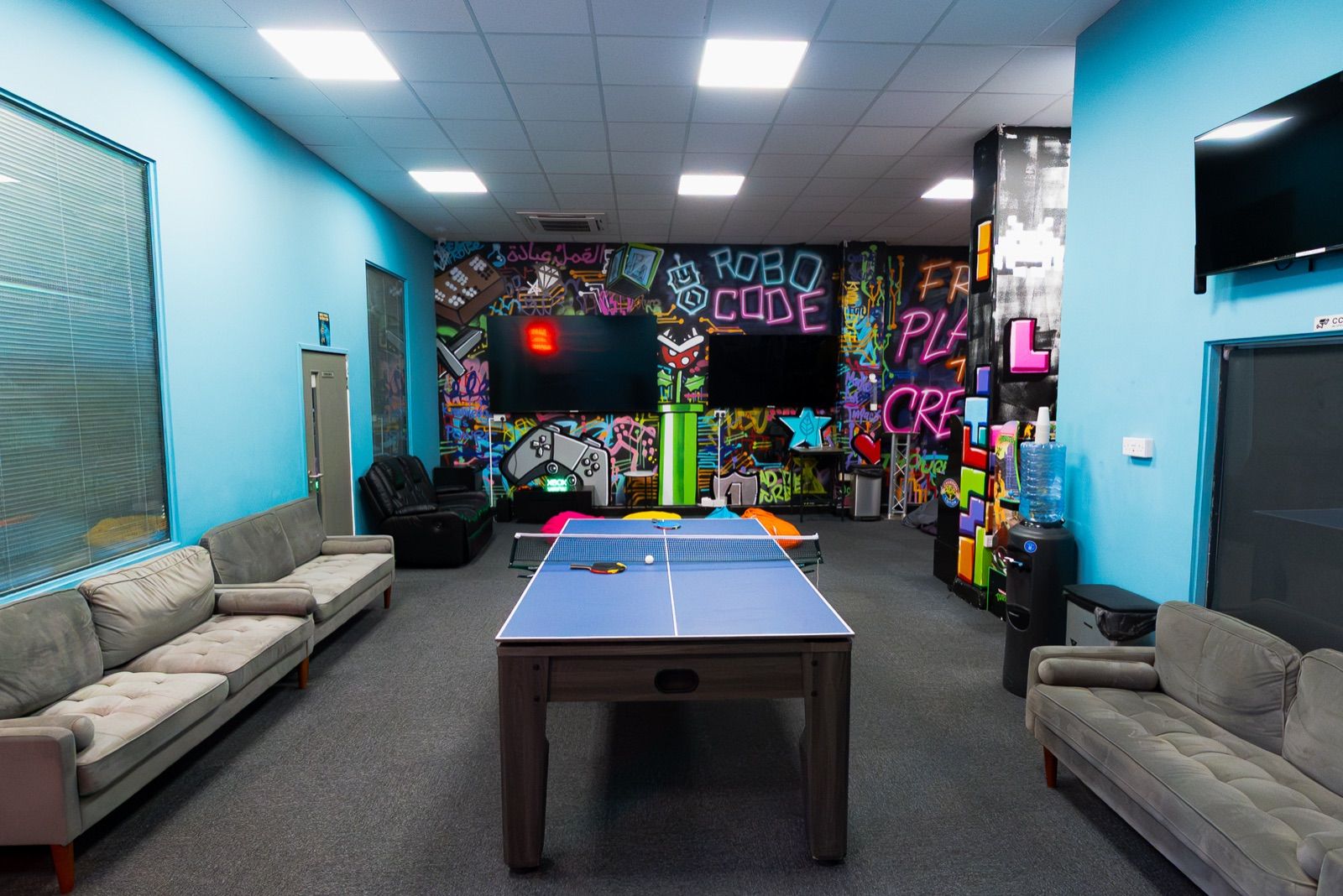 The social space in a Robocode centre, with a graffiti wall and a table tennis table