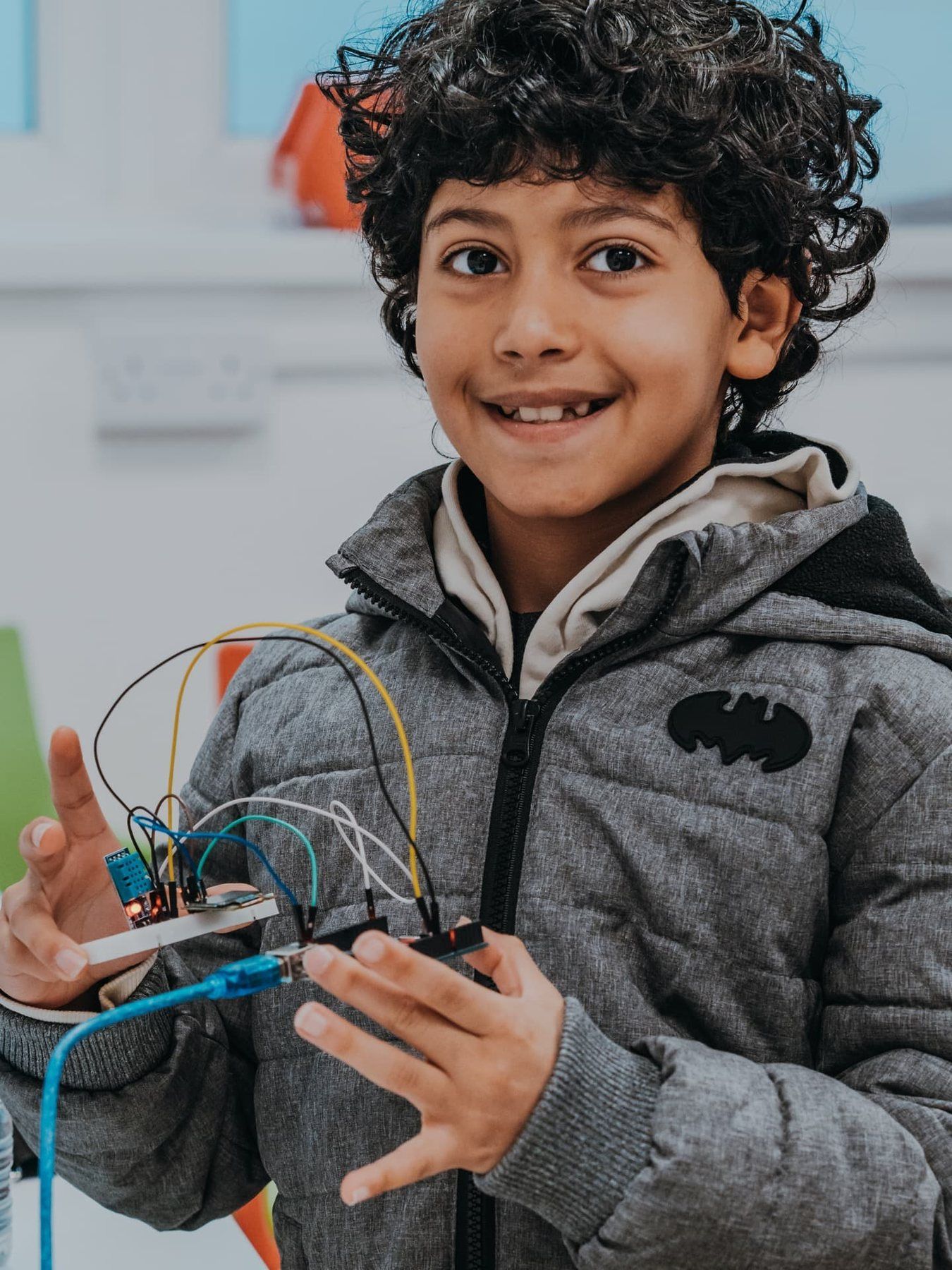 A smiling Robocoder holding up the circuit he wired