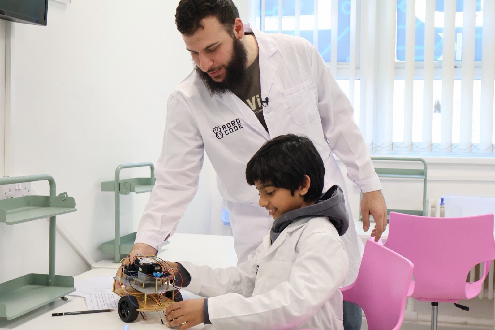 A Mentor helping a Robocoder with his robot car