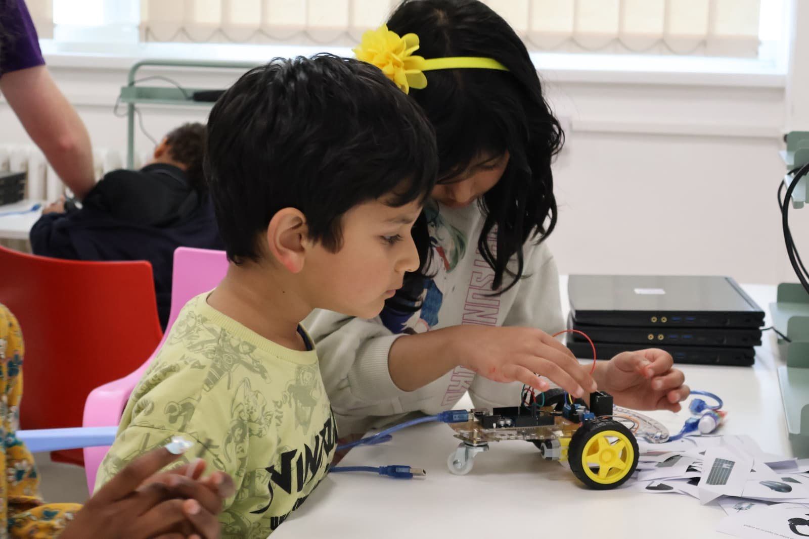 Two Robocoders building a robot car side by side