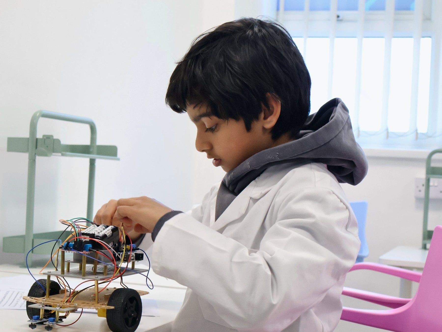 A Robocoder in a lab coat building a line-following robot