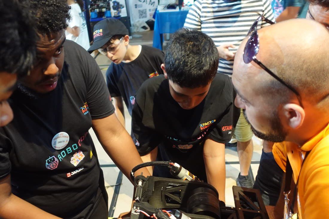 A Mentor and Robocoders working on a competition robot