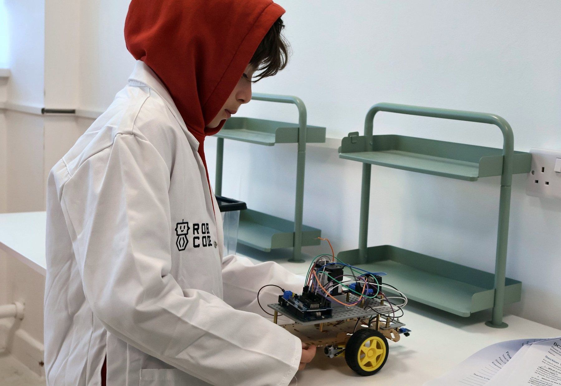 A Robocoder in a Robocode lab coat with his robot car